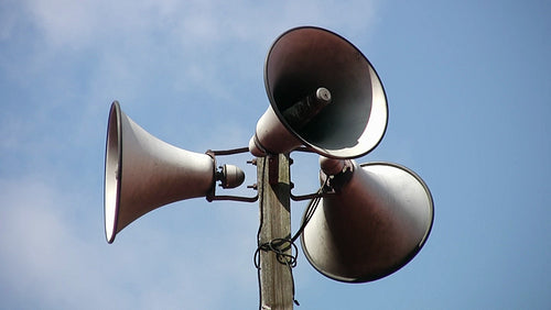 Megaphone tower with three speakers. Clouds in background. HDV footage. HD.