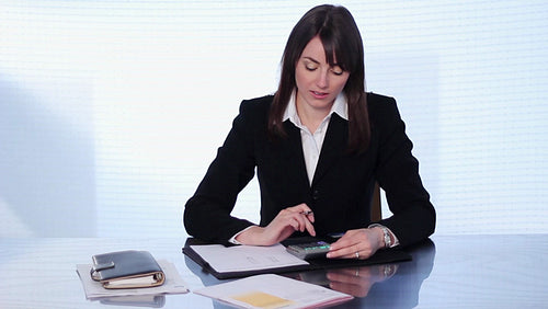 Female executive doing finances at her desk. HD.