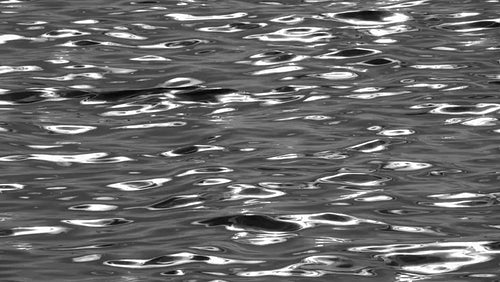 Silky smooth, slow motion lake waves. Black and white. Silver metallic look. HD.