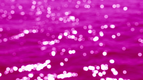 Slo mo defocused highlights on sunlit lake water. Fuchsia tint. Lake Ontario. HD stock video.