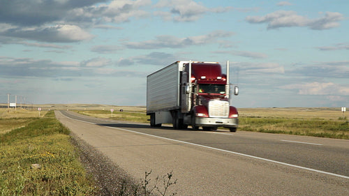 Red truck and car passing on the highway. Saskatchewan, Canada. HD.