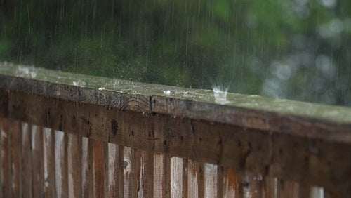 Summer rain falling on wood handrail. Half-speed 4K Clip. Ontario, Canada. 4K.