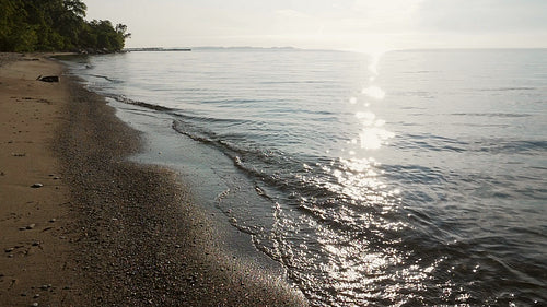 Slow motion sunlit wave and beach. Wide shot. Toronto Islands. HD stock video.