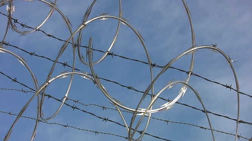 Razor wire. Light cloud time lapse. HD video.