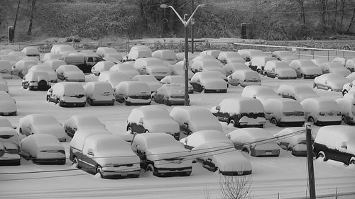 Snowstorm parking lot. Truck drives around snowy parking lot. Black and white. HD video.