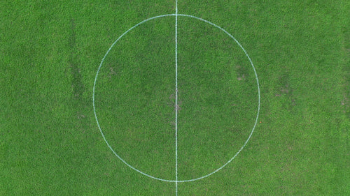 Aerial drone shot rising above football soccer field revealing whole pitch. 4K.