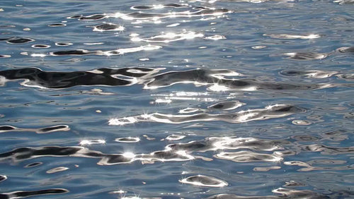 Slow motion metallic looking lake water with sunny highlights. HD.