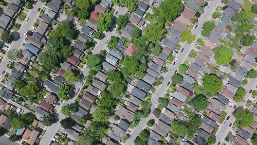 Spinning, descending drone aerial. Stock video of summer suburb with green trees. Toronto. 4K.