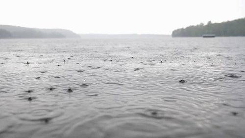 Water level view of rainy lake in Haliburton, Ontario, Canada. Sound of rain. 4K.