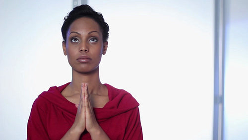 Attractive, young black woman prays. HD.