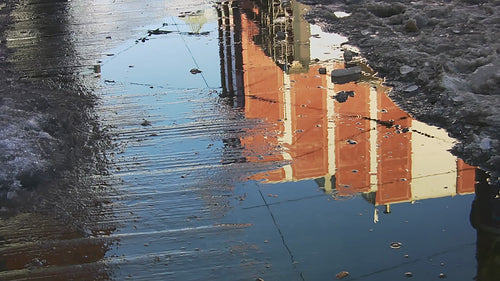 Feet walking through winter puddle in the city. HD video.