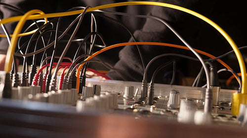 Electronic musician works on a live mix. Modular synthesizer with cables. HD.