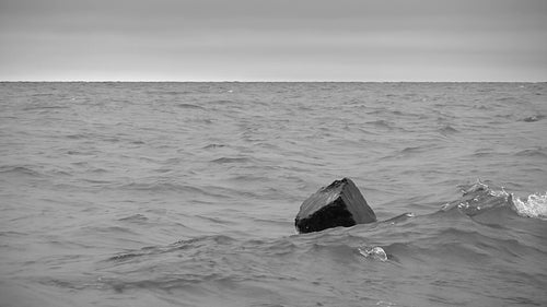 Block of concrete with moody lake. Lake Ontario, Canada. Black & white. HD video.