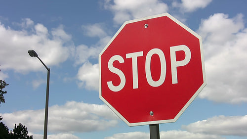 Stop sign with fast moving time lapse clouds. HDV footage. HD.