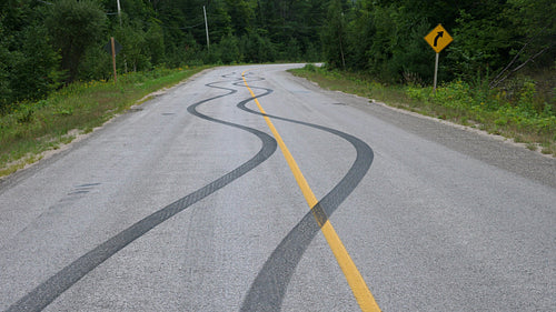 Skid marks on road from car doing a burnout. Haliburton, Canada. 4K.