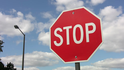 Stop sign with mellow time lapse clouds. HDV footage. HD.