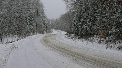 Curvy winter road with no people or cars. Light snow falling. Canada. 4K.