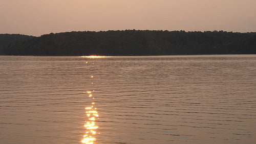 Lake at sunset. Golden sparkles and reflections in the water. Ontario, Canada. 4K.