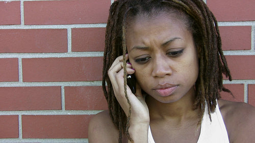 Concerned girl listening and talking on cellphone. HD video.