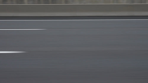 Highway asphalt with white lines and barrier. Great background for copy. 4K.